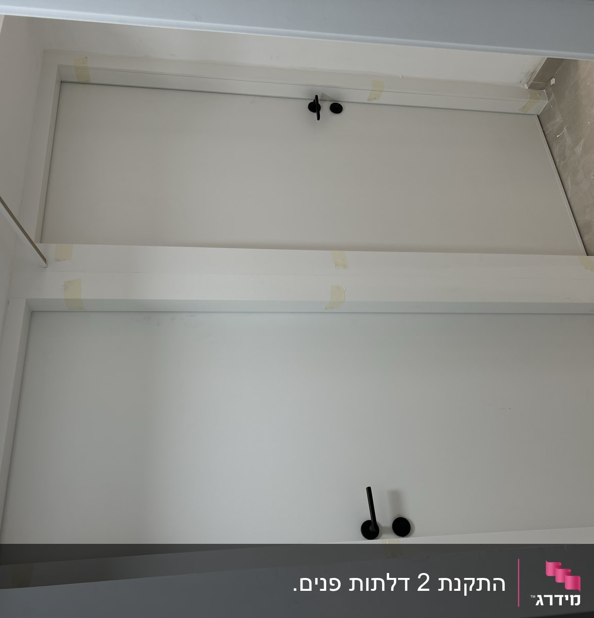 שתי דלתות לבנות עם ידיות שחורות